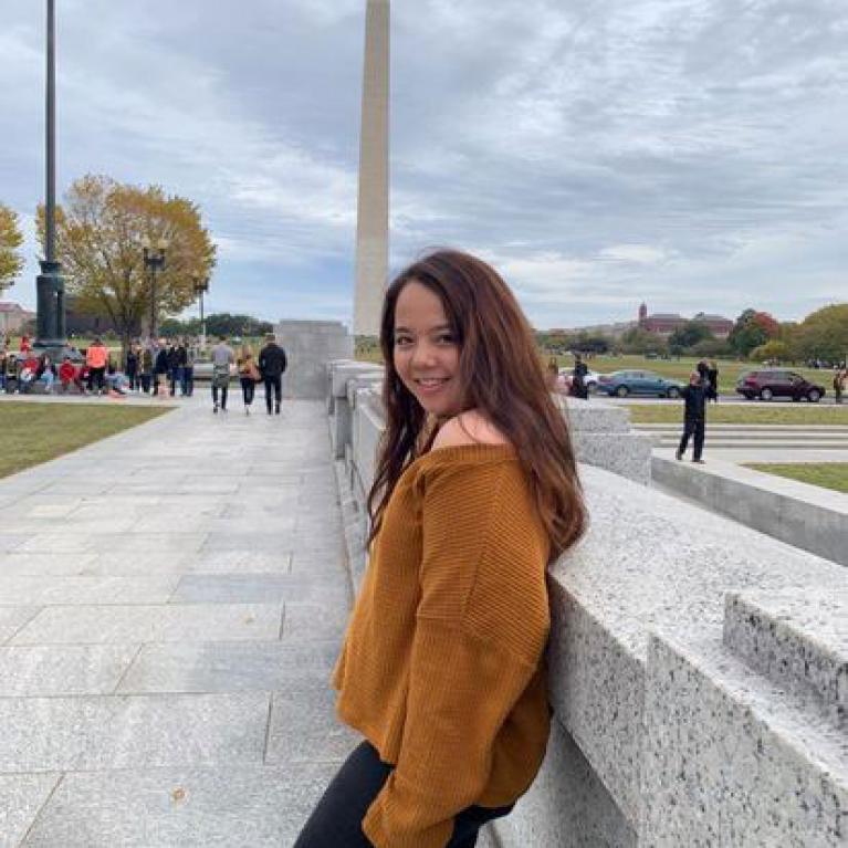 Student posing in front of Washington D.C. memorial, Washington Monument